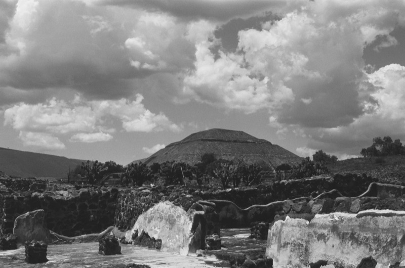 Black-and-white view of the Pyramid of the Sun at Teotihuacan, Mexico, beneath dramatic clouds